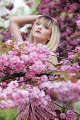 Jeune femme en été dans un cerisier en fleur