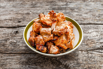 Shashlik grilled meat bbq in the bowl on the old gray oak table outdoors.Copy space.Closeup.