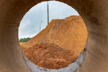 Soil excavation at the construction site. A pile of sand and earth after earthworks. Trench in the ground.