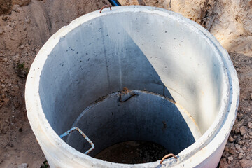 A well made of reinforced concrete rings with water at the bottom. Inside the well. Sewer well from...