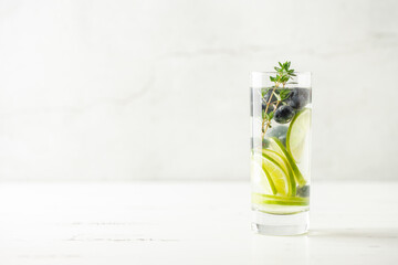 Detox infused water in glass. Refreshing summer homemade cocktail with fruit, berries and citrus