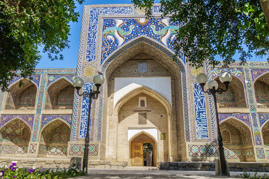Madrasah Nadir-Divan-Begi in Bukhara, Uzbekistan. Building is made unique by the mosaic decorations of the portal depicting the mythical Simurgh birds and the ancient symbol of the sun with a face