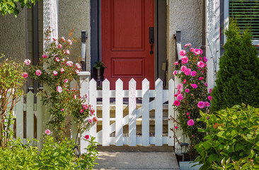 Entrance to a home through a beautiful garden with colorful flowers. Plants and flowers in pots on a doorstep