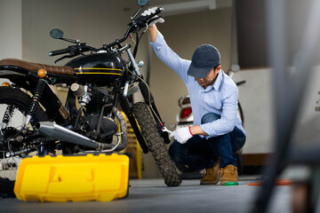 Fototapeta na wymiar Mechanic check brake system on motorcycle brake reservoir in garage.