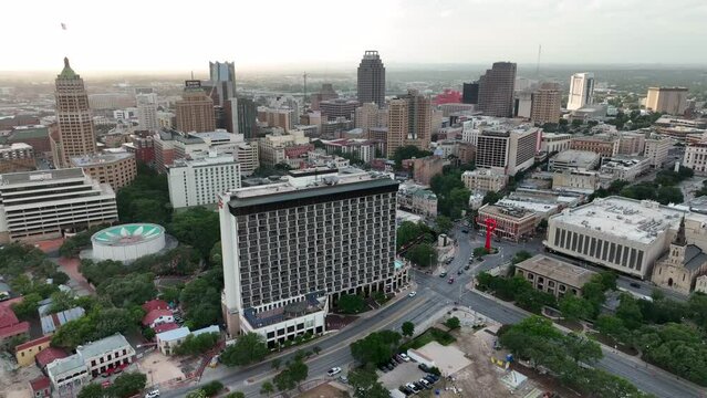 Cinematic wide aerial of San Antonio skyline and tourist attractions during sunset. Riverwalk area and downtown buildings.