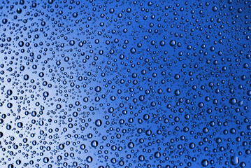 Close-up of blue water drops on glass wall of shower on a sunny summer morning. Photo taken June 30th, 2022, Zurich, Switzerland.