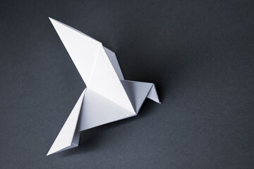 White paper dove origami isolated on a grey background
