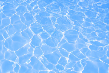 Fototapeta na wymiar Blue water surface with bright sun light reflections, blue water in swimming pool background