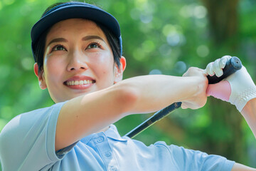 スイングをするゴルフウェアを着た日本人女性