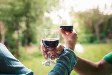 Hands couple woman and man drinking red wine from glasses outside