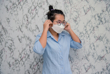 Young Woman puts on a face mask protecting from virus during quarantine isolated on White background , Covid-19