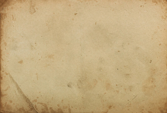 The texture of an old shabby dirty cardboard photo card with a crumpled corner, the texture of an old yellowed dirty paper with stains and scuffs