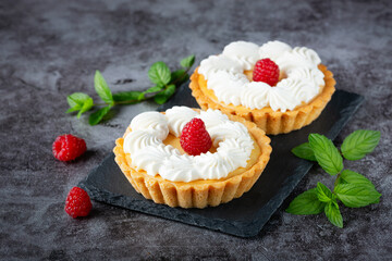 Creamy cheesecake cake with raspberries on a gray table