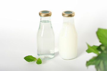 glass bottles with shampoo and conditioner. refill package, zero waste and sustainable lifestyle. no plastic beauty care. natural mint leaves.