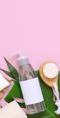 Cosmetic bottle, skin and hair care accessories on palm leaves on pink, mockup, copy space