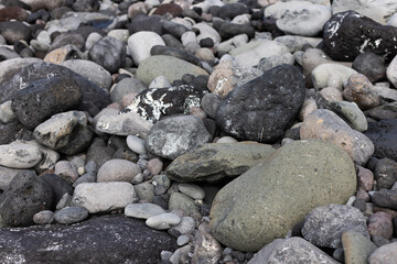 Texture of the seashore with big and small stones. Natural background.