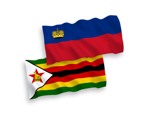 National vector fabric wave flags of Liechtenstein and Zimbabwe isolated on white background. 1 to 2 proportion.