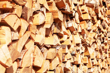 Textured firewood background of chopped wood for kindling and heating the house, a woodpile with stacked firewood. Concept of economic fuel crisis.