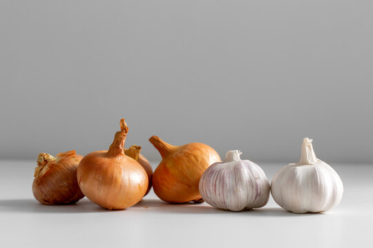 food, vegetable and healthy eating concept - onion and garlic on table