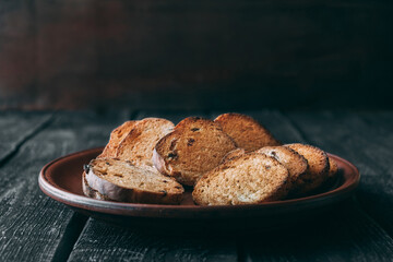 Sliced dry, baked bread with raisins on clay plate
