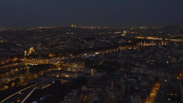 Boats sailing on the Seine near the Passerelle Debilly footbridge and panorama of Paris at night