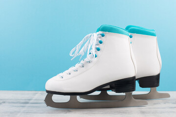 Pair of ice skaters in front of a blue background, winter sport equipment
