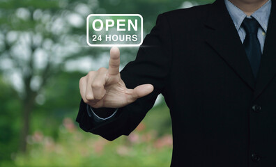 Businessman pressing open 24 hours flat icon over blur flower and tree in park, Business full time service concept