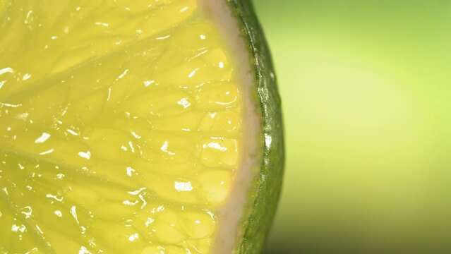 Drop of water flows down the surface of a ripe juicy Lime slice. Slow Motion 4K
