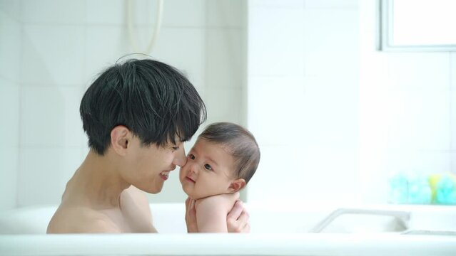 赤ちゃんをお風呂に入れる男性