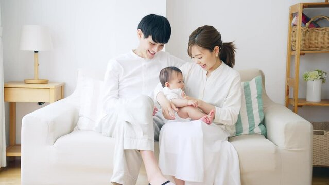 赤ちゃんを抱っこするカップル　子育てイメージ