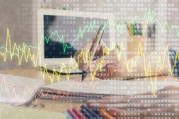 Financial forex charts displayed on woman's hand taking notes background. Concept of research. Double exposure