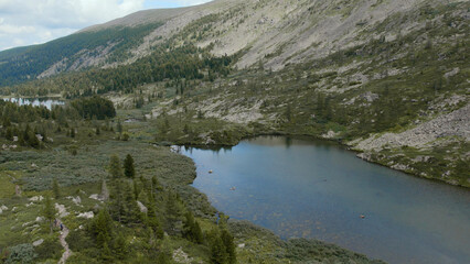 Karakol lakes in mountains of Altai under blue sky with white clouds