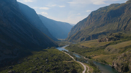 Fototapeta premium River Chulyshman between green field and mountains with blue clear sky in Altai