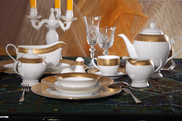 Elegant table setting with luxury china dinnerware. Golden design porcelain dishes.