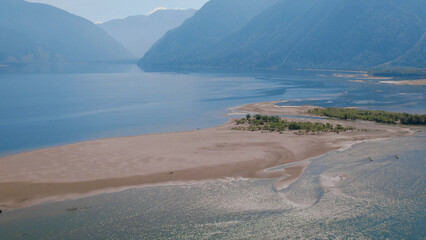 Lake Teletskoye between mountains with blue clear sky in Altai