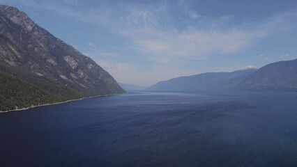 Lake Teletskoye between mountains with blue clear sky in Altai