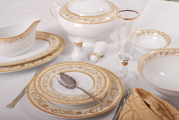 Elegant table setting with luxury china dinnerware. Golden design porcelain dishes.