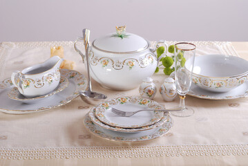 Elegant table setting with luxury china dinnerware. Golden design porcelain dishes.