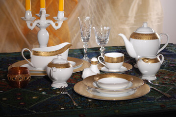 Elegant table setting with luxury china dinnerware. Golden design porcelain dishes.