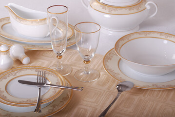 Fototapeta na wymiar Elegant table setting with luxury china dinnerware. Golden design porcelain dishes.