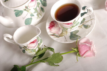 Obraz na płótnie Canvas Beautiful bone-china tea set with tea pot and cups and saucers. Minimal and elegant design.