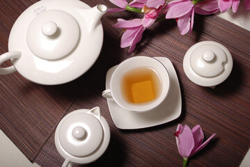 Obraz na płótnie Canvas Beautiful bone-china tea set with tea pot and cups and saucers Elegant and minimal design.