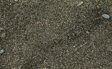 Lines of black sand on the beach.