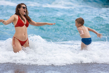 Italy. Positano. A woman with a child is bathing in the waves of the sea.