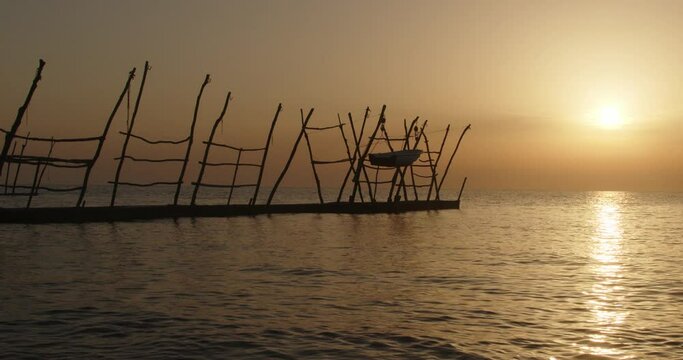 Hanging boats of Savudrija Boats hanging from traditional wooden cranes at sunset