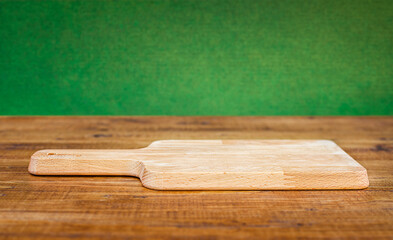 cutting board close up on wooden table on green background