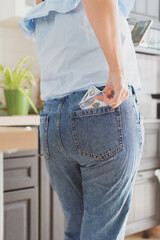 close-up female hands take money out of the back pocket of jeans