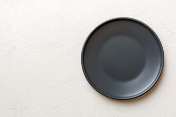 Top view of black plate on cement background. Empty space for your design