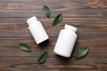supplement pills with medicine bottle health care and medical top view. Vitamin tablets. Top view mockup bottle for pills and vitamins with green leaves, natural organic bio supplement, copy space