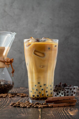 Bubble tea with coffee and chocolate in glass cup on dark background.